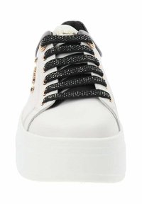 Zapatilla plataforma blanca con cordones negros y brillantes, ojales dorados y textura de piel suave. Punta redondeada y diseño de perfil bajo.
