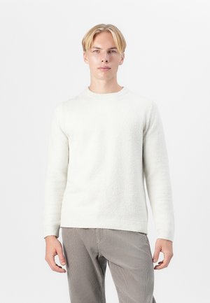 White, textured sweater with a crew neck, long sleeves, and a relaxed fit. Paired with light gray, ribbed corduroy pants.