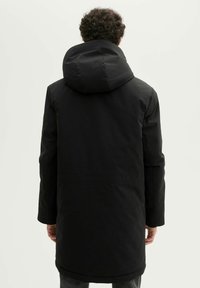 Musterniga musta parka, millel on kapuuts, sirge lõikega, pikad varrukad ja sile, matte tekstuur. Ilma nähtava riistvara või mustriteta.