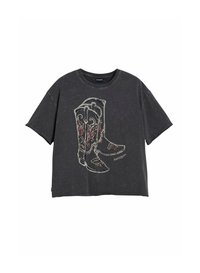 T-shirt noir oversize à manches courtes avec un motif brodé de bottes de cowboy en fils rouge, blanc et doré.