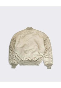 Cream bomber jacket with ribbed collar and cuffs, featuring padded shoulders and a smooth, glossy texture. Visible stitched accents.