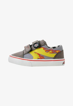 Grauer und gelber Kindersneaker mit rotem Flammendesign, zwei Klettverschlüssen, darunter einer mit Lenkrad-Dekoration, weiße Sohle mit rotem Streifen.