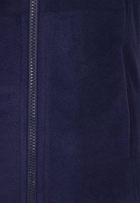 Navyblaue Fleecejacke mit glatter Textur, ausgestattet mit einem zentralen Reißverschluss und zwei seitlichen Taschen für zusätzlichen Komfort.