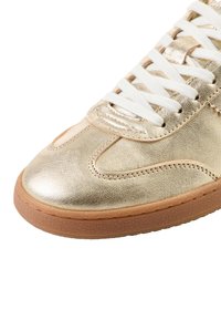 Gouden metallic sneaker met witte veters, gladleren bovenzijde, afgeronde neus en buitenzool van gumrubber met gestructureerde details.