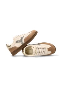 Zapatillas en cuero color crema y marrón claro con acabado de ante. Presentan detalles de brillo, puntera redonda, suela plana y diseño con cordones.