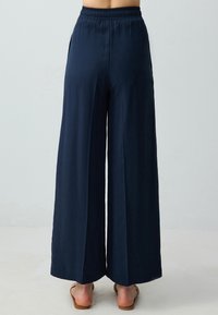 Marine wijd pijp broek met een elastische tailleband, platte voorkant, twee zijzakken en een gladde, lichte stof.