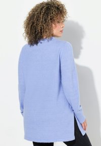 Langärmliger, helllila Pullover mit lässiger Passform, seitlichen Schlitzen und gerippten Bündchen. Weiche Textur mit runder Ausschnittform.