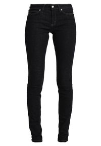 Jeans skinny negros fabricados en denim, con un clásico diseño de cinco bolsillos, herrajes plateados y detalles de costura visibles.