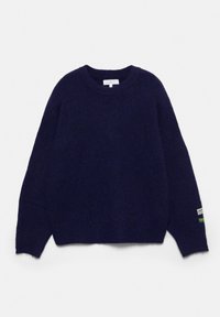 Temno modra pletena majica z dolgimi rokavi, okroglim izrezom in dvema majhnima platnenima etikama na levi manšeti.