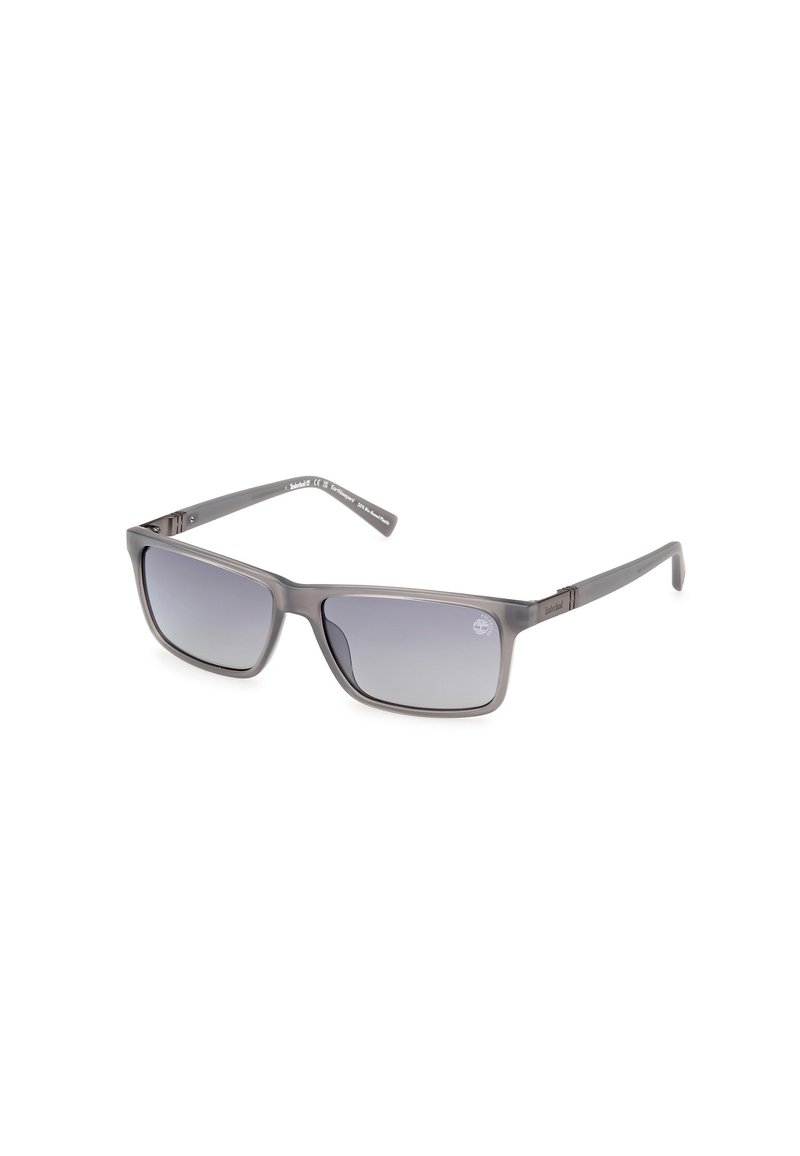 Gafas de sol grises con un marco rectangular, lentes de degradado y un diseño elegante y ligero. Presenta una sutil marca en las patillas.