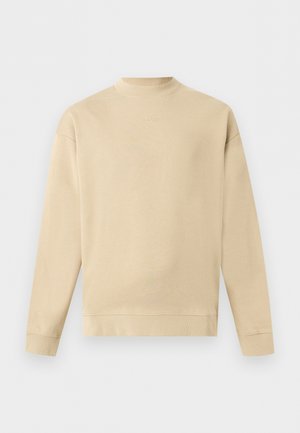 Beige sweater met lange mouwen en ronde hals, geribbelde boorden en zoom, klein "HUGO"-logo gecentreerd onder de hals.