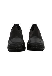 Pair of black slip-on sneakers with textured soles and pull tabs at the back, shown from the front on a white background.