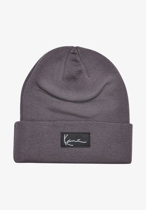Graue gestrickte Mütze mit umgeschlagenem Rand und einem schwarzen rechteckigen Etikett mit weißer, kursiver Schrift "Karim" auf der Vorderseite.