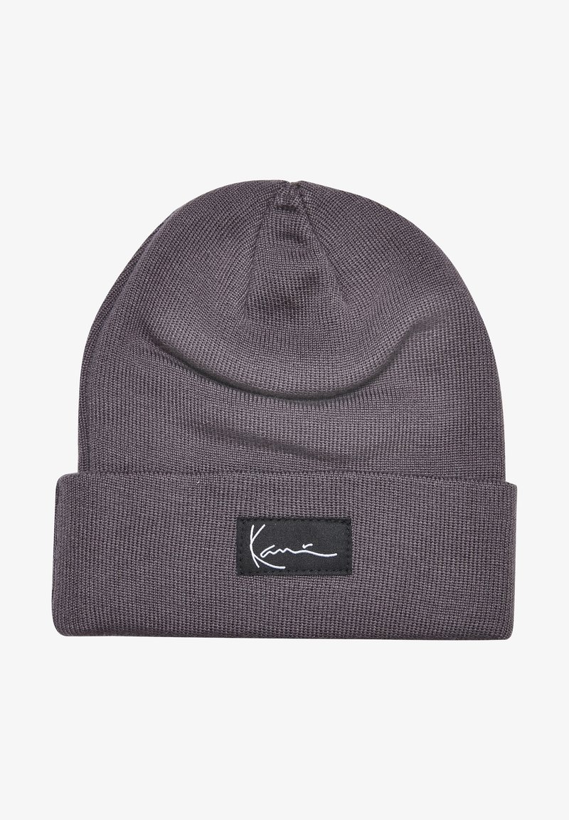 Bonnet tricoté gris avec revers, orné à l'avant d'une étiquette rectangulaire noire portant le texte cursif blanc "Karim".
