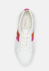 Baltos sportiniai bateliai su rožiniais ir oranžiniais zomšiniais akcentais, turintys apvalią noselę, raištelių uždarymą ir mažą logotipą šone.