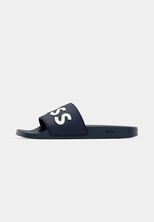 Navy blue slide sandal made of rubber featuring a wide strap with white "BOSS" logo, flat sole, and smooth texture.