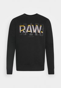 Felpa nera con la scritta "RAW." in caratteri audaci e multicolori sul retro. Il materiale è morbido; il design ha un collo rotondo e polsini a coste.