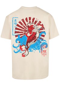 Beige katoenen t-shirt met een grafisch ontwerp van rode koi-vissen tegen blauwe golven en een zonnestraal, met Japanse karakters en accenten.