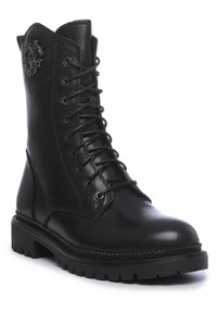 Botte de combat noire en cuir à lacets avec semelle épaisse et logo embossé sur le côté supérieur, montrant les détails avant et côté extérieur.
