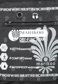 Svart yttertyg med Marikoo-logotyp, vattentäta etiketter, blommönster och hörlursport. Inkluderar skötsel- och materialinformation.