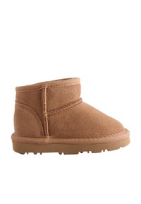 Beiger Wildleder-Stiefelette mit abgerundetem Zehenbereich, abgesteppten Nähten und einer flachen Gummisohle. Weiche Textur und minimalistisches Design.