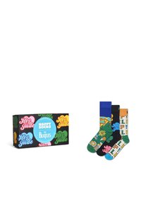 Ensemble de quatre paires de chaussettes présentant différentes couleurs et motifs, y compris des designs floraux et textuels. La boîte affiche une marque colorée "Happy Socks".