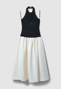 Bodice nero a halter che si trasforma in una gonna bianca e fluida. Tessuto morbido, con chiusura posteriore e spalline regolabili.