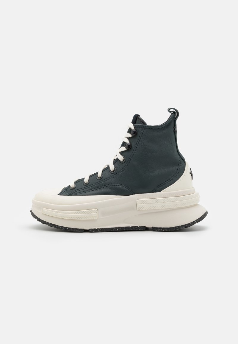 High-top sneaker in dark green leather with cream rubber sole. Features white laces, contrast stitching, and a textured heel tab.