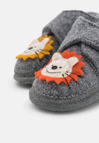 Gray felt slippers with lion face appliqués in orange and yellow. Features a simple strap design and textured rubber soles.