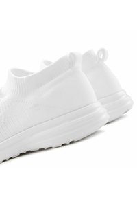Scarpe slip-on bianche realizzate in tessuto a maglia con un colletto a coste, dotate di una suola liscia e piccoli tiranti sul tallone.
