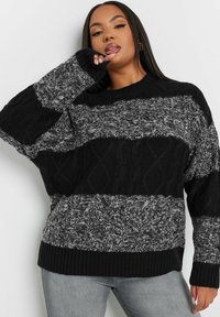 Gestreifter Pullover in Schwarz und Grau mit einer Mischung aus strukturierten Strickmustern, gerippten Bündchen und einem entspannten Schnitt mit Rundhalsausschnitt.