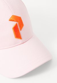 Roze baseballcap met een gebogen klep, voorzien van een oranje geborduurd geometrisch logo op de voorkant en een gestructureerde stof.