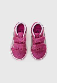 Des chaussures à paillettes roses dotées d'un design à bande velcro et d'accents argentés, avec une semelle blanche et un upper texturé. La doublure intérieure est douce et rembourrée.