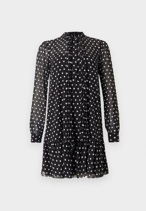 Vestido negro de manga larga con lunares blancos, tela transparente, cuello alto con detalle de lazo, mangas con puños y dobladillo con volantes.