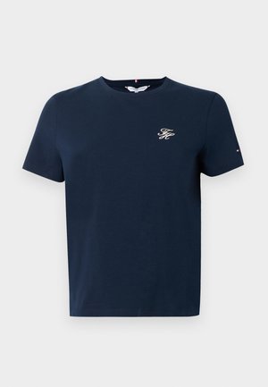 Námornícko modré tričko s krátkym rukávom z bavlny s okrúhlym výstrihom a vyšívaným logom na hrudi. Obsahuje malú trojfarebnú vlajku na rukáve.
