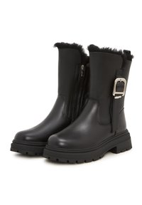 Botas de tobillo de cuero negro con un borde de pelo de felpa, cremallera lateral y una hebilla decorativa de metal. Suela de goma gruesa con un patrón texturizado.