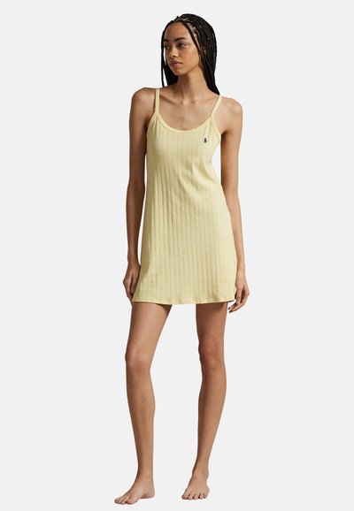 Yellow ribbed knit dress with thin straps, knee-length, featuring a small logo accent on the left chest and soft texture.