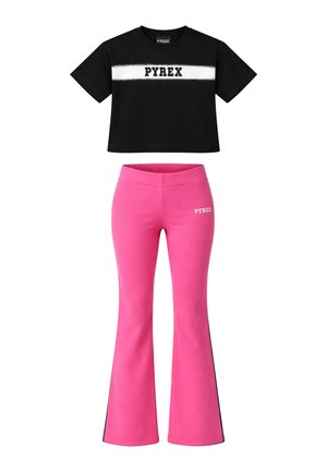 T-shirt corta nera con striscia orizzontale bianca e scritta "PYREX", abbinata a pantaloni rosa a vita alta e svasati con piccolo logo sulla coscia.