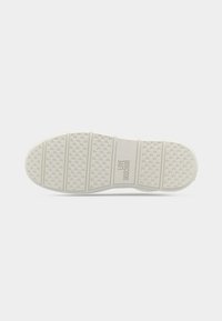 Λευκή σόλα παπουτσιού με υφή αντιολισθητικού σχεδίου και το λογότυπο "LOVE MOSCHINO" ανάγλυφο στο κέντρο, απεικονιζόμενη σε απλό λευκό φόντο.