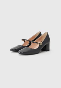Black leather heels with a square toe, featuring a thin strap and gold buckle detail. Block heel for added stability and comfort.