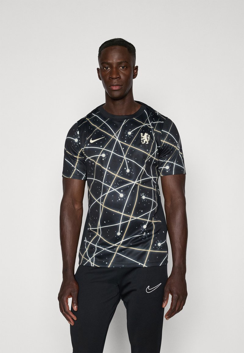 Juodas trumpomis rankovėmis marškinėliai su galaktikos raštu, kuriame matosi šviesios linijos ir taškai, auksinis Nike logotipas ir Chelsea emblema.