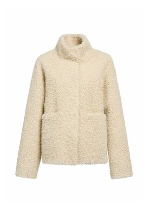 Kremowa polarowa kurtka z miękką, teksturowaną powierzchnią, wysokim kołnierzem i dwiema kieszeniami z przodu. Charakteryzuje się luźnym krojem i brakiem widocznych zapięć.
