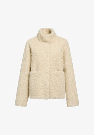 Kremowa polarowa kurtka z miękką, teksturowaną powierzchnią, wysokim kołnierzem i dwiema kieszeniami z przodu. Charakteryzuje się luźnym krojem i brakiem widocznych zapięć.