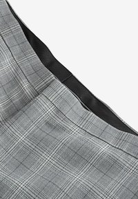 Jupe à carreaux gris en tissu texturé. Dotée d'une taille noire lisse et d'un motif à carreaux classique avec des accents blancs.