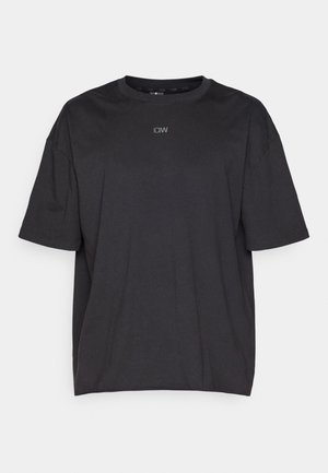 T-shirt preto de manga curta feito em algodão. Apresenta um decote redondo e um logótipo discreto no peito, oferecendo um ajuste relaxado e boxy.