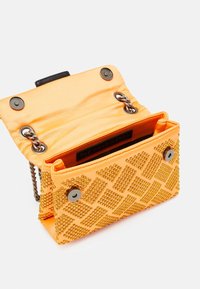 Oranžová kabelka z lesklého saténu s texturovaným povrchem zdobeným nýty v diamantovém vzoru, řetízkovým popruhem a magnetickým zapínáním. Vnitřní kapsa je viditelná.