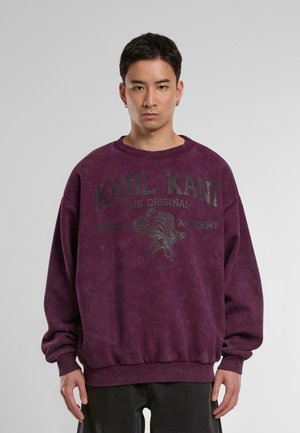 Lila übergroßer Sweatshirt mit einem Grafikdruck eines Adlers und dem Text "KARL KANI THE ORIGINAL STREET ACADEMY." Rippbündchen und Saum.