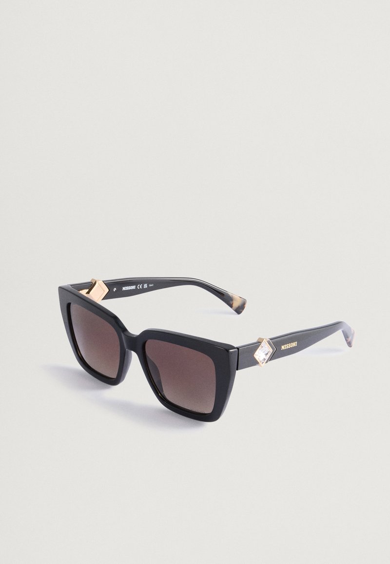 Črne oversized kvadratne sončna očala z gradijentnimi rjavimi lečami. Imajo zlate diamante v obliki romba na ušesnih delih. Stilski detajli iz želve.