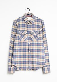 Camisa de cuadros con botones en la parte delantera, dos bolsillos en el pecho y una etiqueta en el bolsillo izquierdo. Patrón de cuadros en azul, crema y rojo; mangas largas.