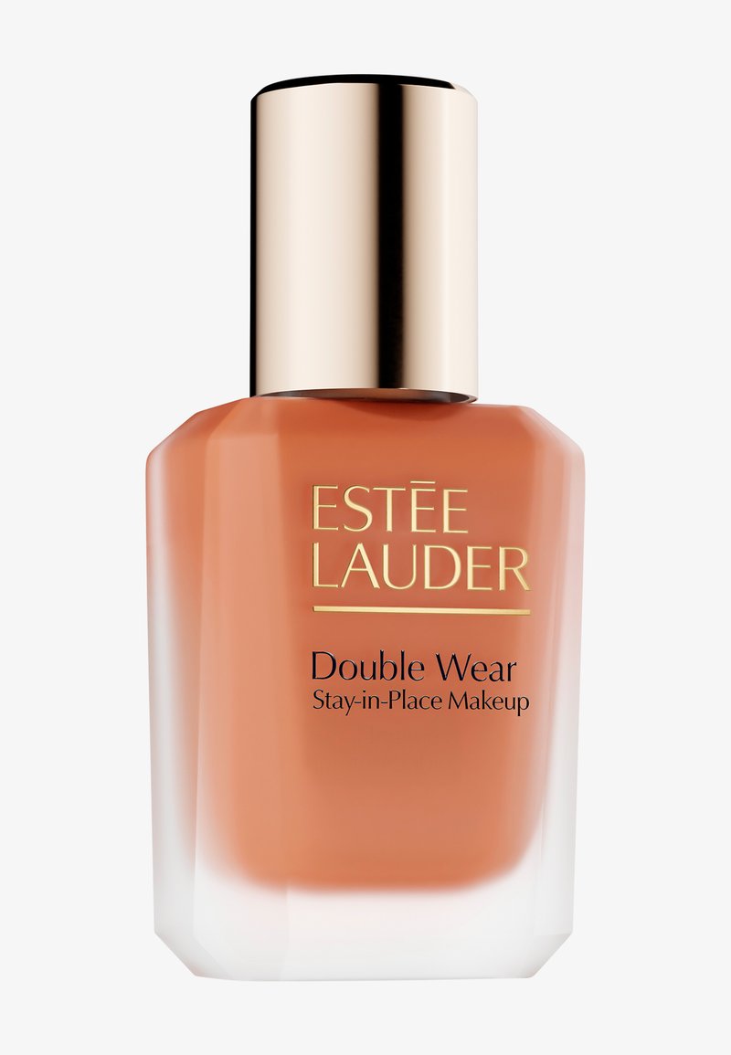 Fond de teint Estee Lauder Double Wear dans un flacon en verre carré avec une teinte orange, un bouchon doré et un texte noir sur le devant.